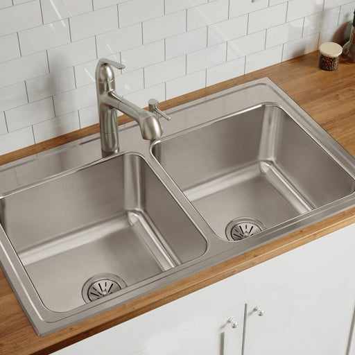 Stainless steel double-bowl sink installed in a wood kitchen countertop