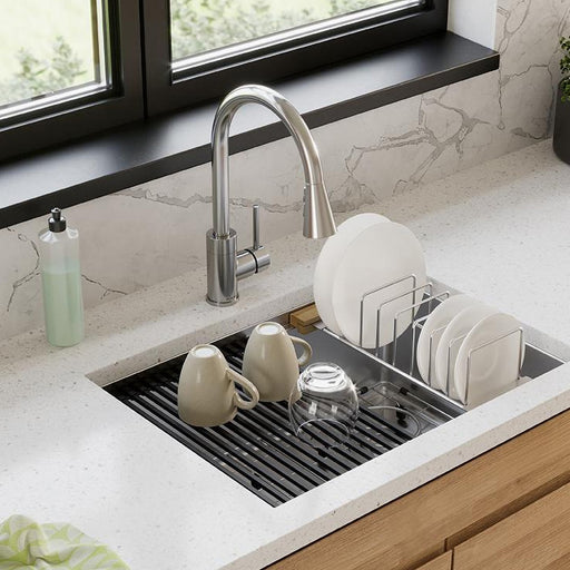 Stainless steel dish rack holding plates over a kitchen sink