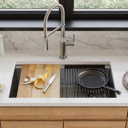 Wood cutting board and dish rack fitted over a stainless steel kitchen sink