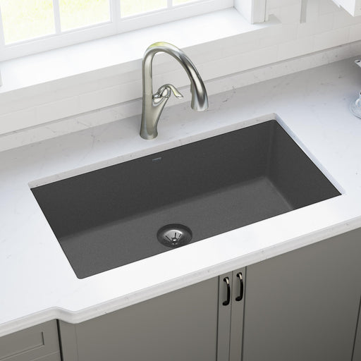 Dark rectangular quartz kitchen sink installed in a light countertop