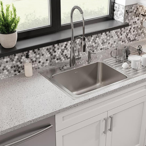 Stainless steel sink with integrated drainboard installed beneath a window