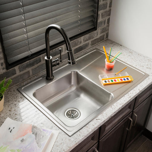 Double-bowl stainless steel sink with an integrated drainboard and a black faucet