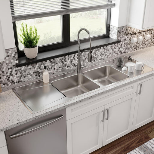 Long stainless steel kitchen sink installed beneath a window