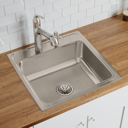 Stainless steel single-bowl kitchen sink installed in a wood countertop