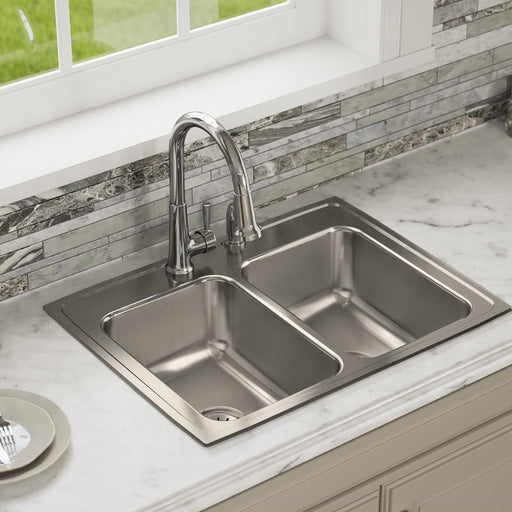 Stainless steel double-bowl kitchen sink installed in a light countertop