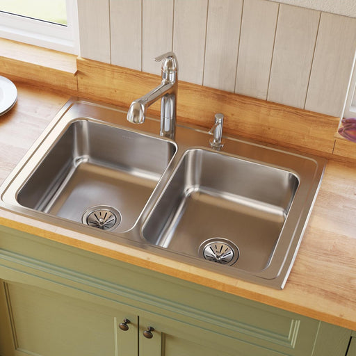 Stainless steel double-bowl kitchen sink installed in a wood countertop