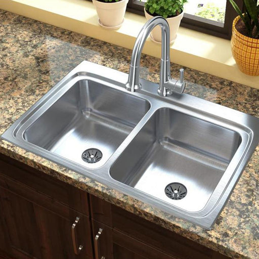 Stainless steel double-bowl sink installed beneath a kitchen window