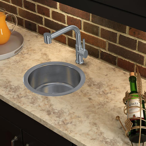 Round stainless steel sink set into a stone countertop