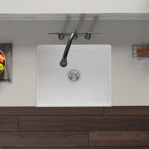 Overhead view of a white kitchen sink with installed drain
