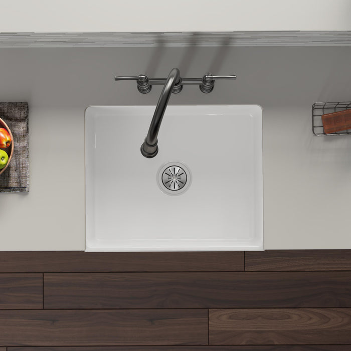 Overhead view of a white kitchen sink with installed drain