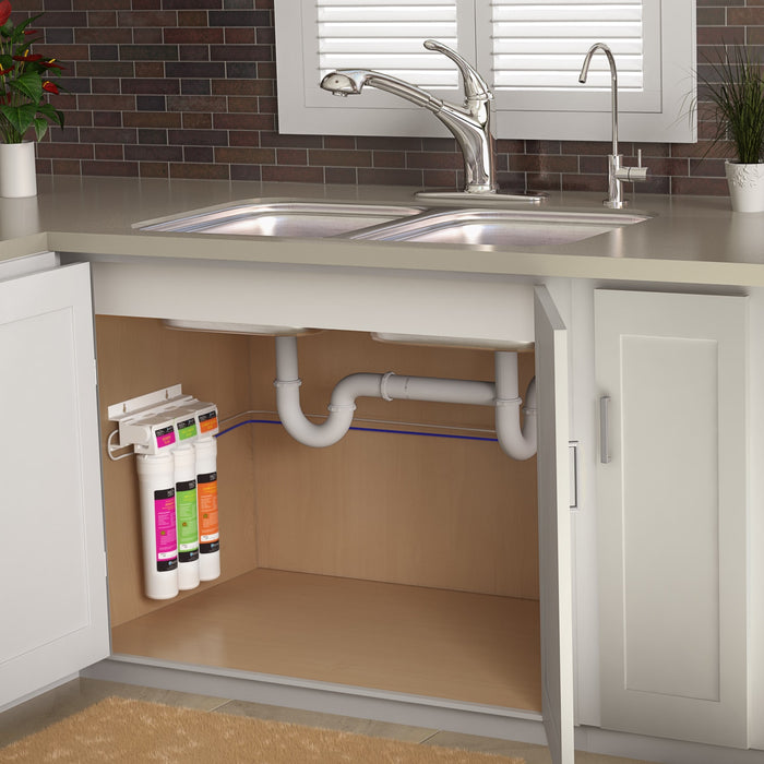 Undercounter housing with three water filter cartridges and connected white tubing